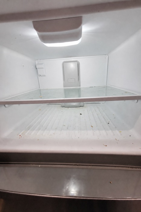 Freezer interior with crumbs and spills before a NeatNow clean in Calgary