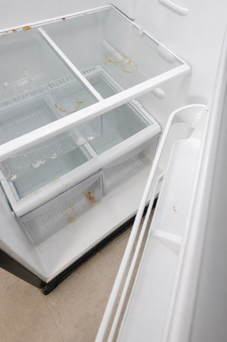 Refrigerator interior with food residue and stained drawers before a NeatNow clean in Calgary